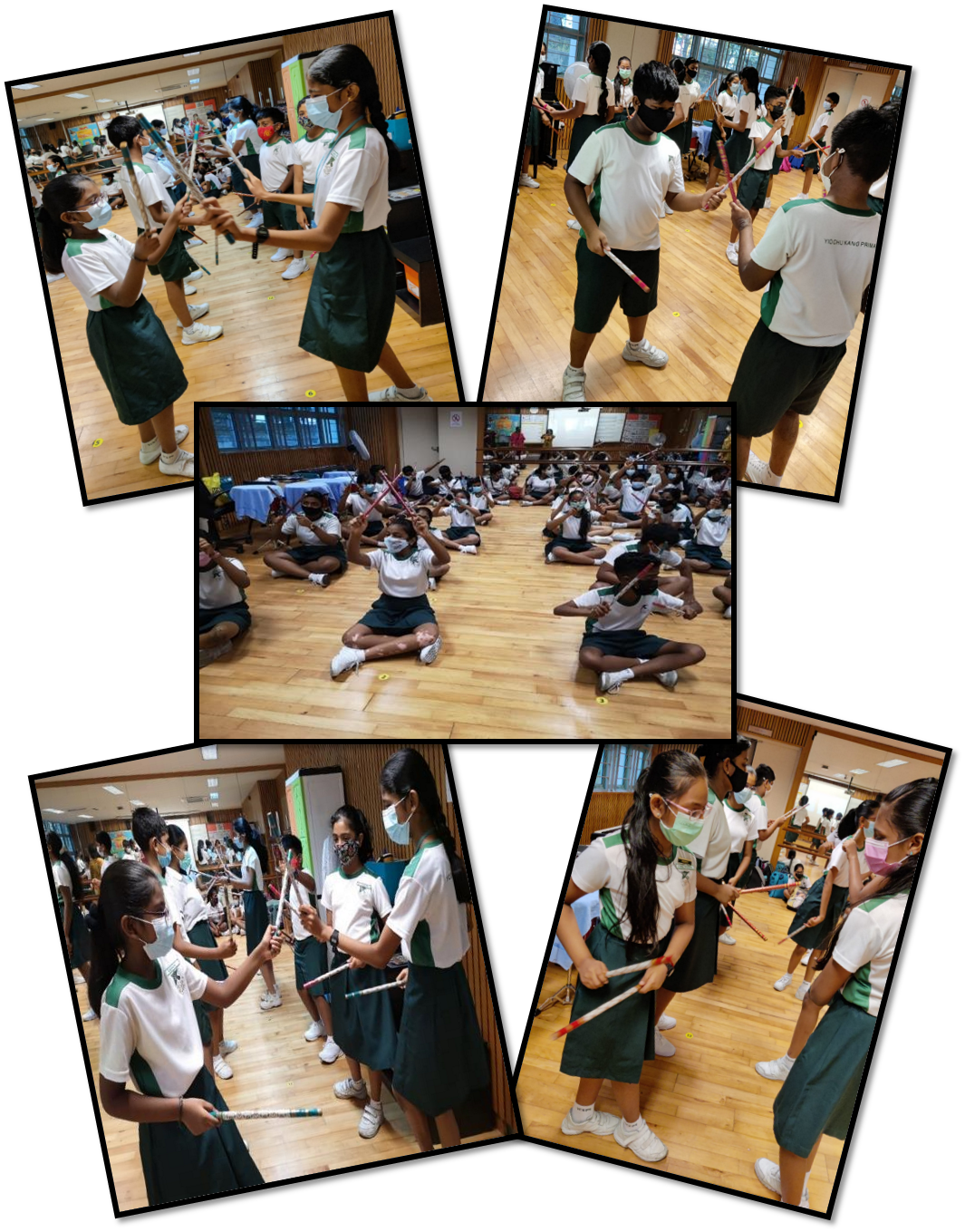 Students in white and green uniforms with masks practice stick-based activities in a school hall.